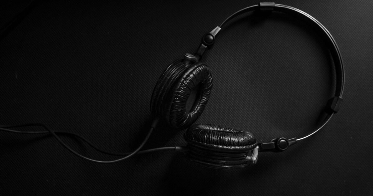 Studio headphones on a dark surface, listening to a voice over demo