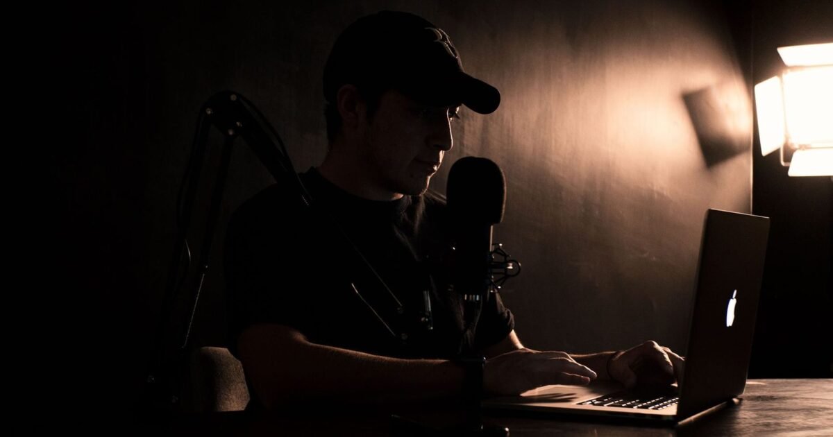 Comédien débutant au micro dans un studio d'enregistrement sombre