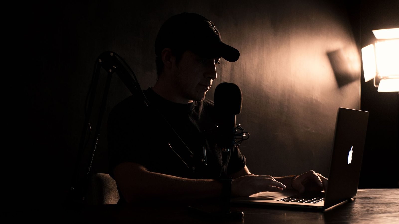 Comédien débutant au micro dans un studio d'enregistrement sombre