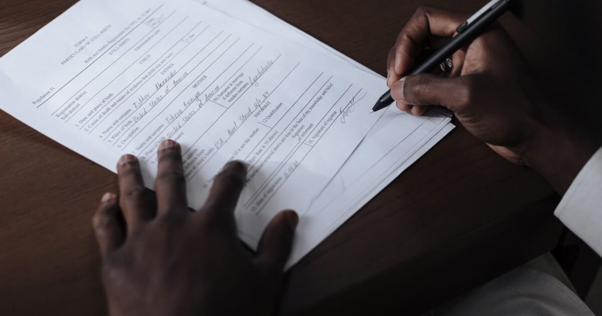 Signature d'un contrat de cession de droits sur un bureau sombre