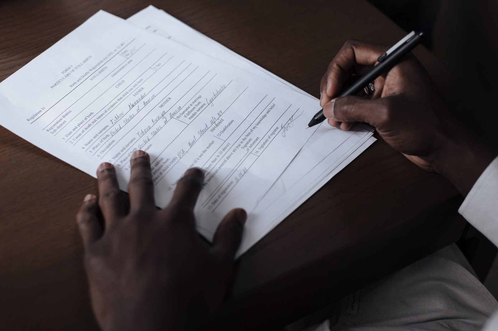 Signature d'un contrat de cession de droits sur un bureau sombre