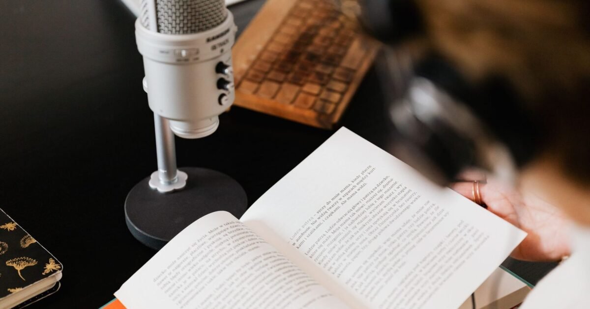Open book beside a studio microphone, preparing an audiobook recording