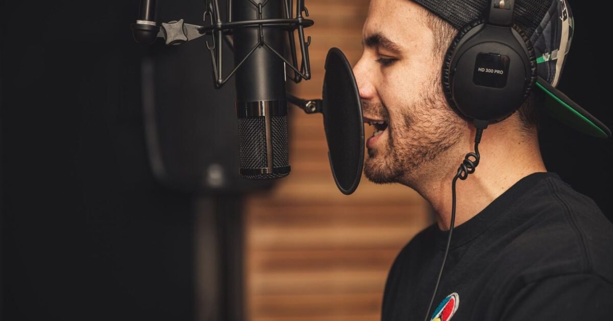 Comédien voix-off au micro, casque sur les oreilles, pendant une prise