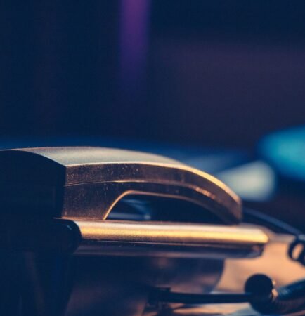 Téléphone de bureau posé sur un plan de travail sombre