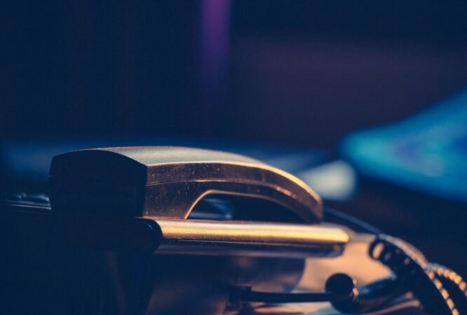 Téléphone de bureau posé sur un plan de travail sombre