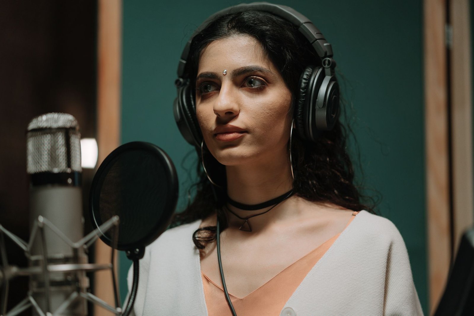 Comédienne au casque en séance d'enregistrement devant un microphone de studio