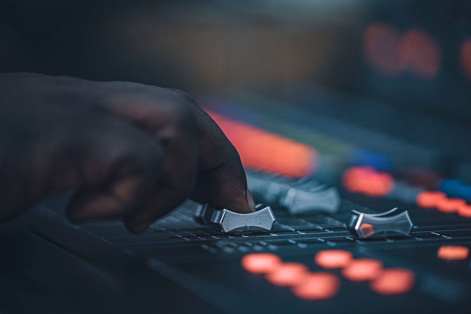 Main d'ingénieur du son sur les faders d'une console de mixage