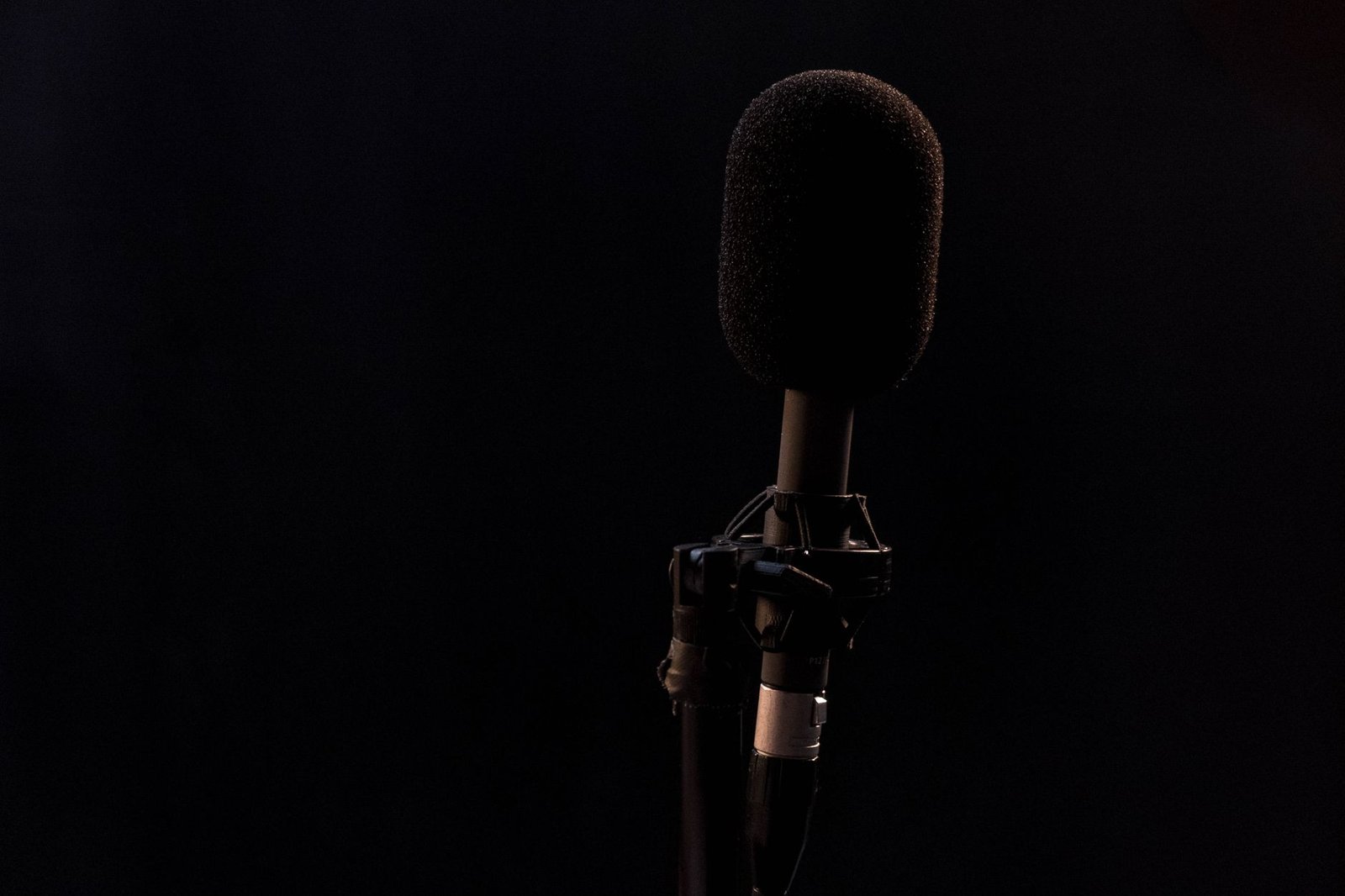 Microphone avec bonnette en studio d'enregistrement sombre