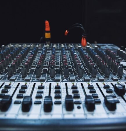 Console de mixage d'un studio d'enregistrement éclairée dans la pénombre d'une régie