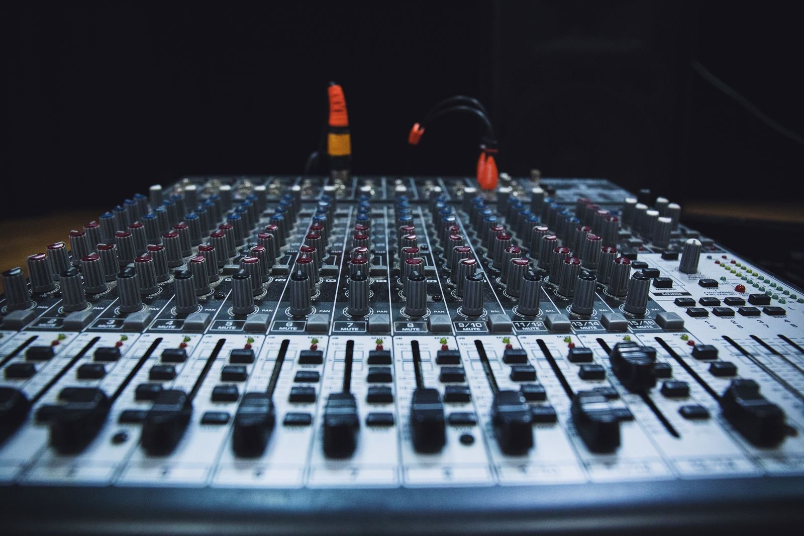 Console de mixage d'un studio d'enregistrement éclairée dans la pénombre d'une régie